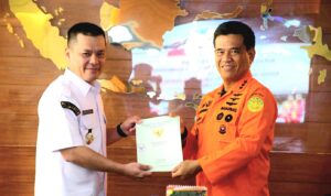 Pj Bupati Kayong Utara, Romi Wijaya menyerahkan sertifikat tanah untuk pembangunan Unit Siaga SAR kepada Basarnas, di Gedung Badan Nasional Pencarian dan Pertolongan, Jakarta, Rabu (01/11/2023). (Foto: Prokopim/Santo)