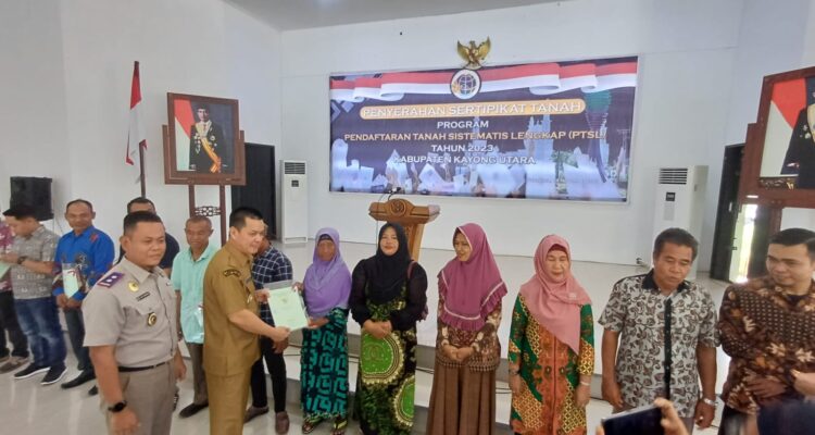 Penyerahan sertifikat tanah program PTSL kepada sejumlah warga di Aula Istana Rakyat, Kecamatan Sukadana, Selasa (14/11/2023). (Foto: Santo)