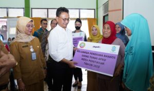 Wali Kota Pontianak, Edi Rusdi Kamtono menyerahkan secara simbolis bantuan Jaminan Kesehatan Nasional (JKN) dan bansos tunai kepada keluarga penerima manfaat. (Foto: Prokopim Pontianak)
