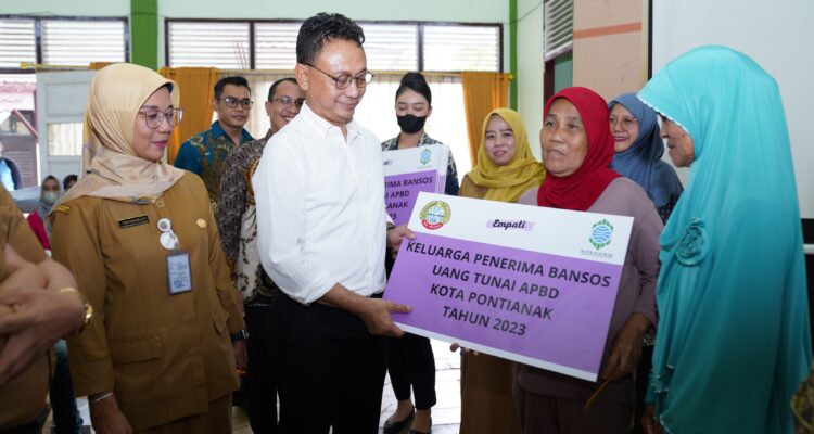 Wali Kota Pontianak, Edi Rusdi Kamtono menyerahkan secara simbolis bantuan Jaminan Kesehatan Nasional (JKN) dan bansos tunai kepada keluarga penerima manfaat. (Foto: Prokopim Pontianak)