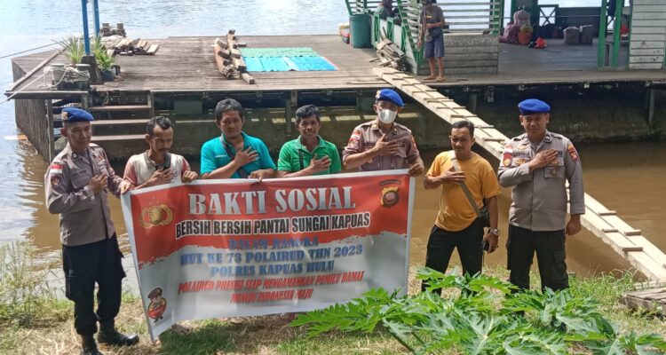 Sat Polair Polres Kapuas Hulu foto bersama masyarakat di sela-sela melaksanakan pembersihan pesisir dan sungai. (Foto: Ishaq)