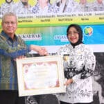 Penjabat Gubernur Kalbar, Harisson menyerahkan penghargaan Widya Praja Provinsi Kalimantan Barat kepada Bupati Mempawah, Erlina atas dedikasinya dalam membangun dunia pendidikan, Sabtu (25/11/2023). (Foto: Jauhari)