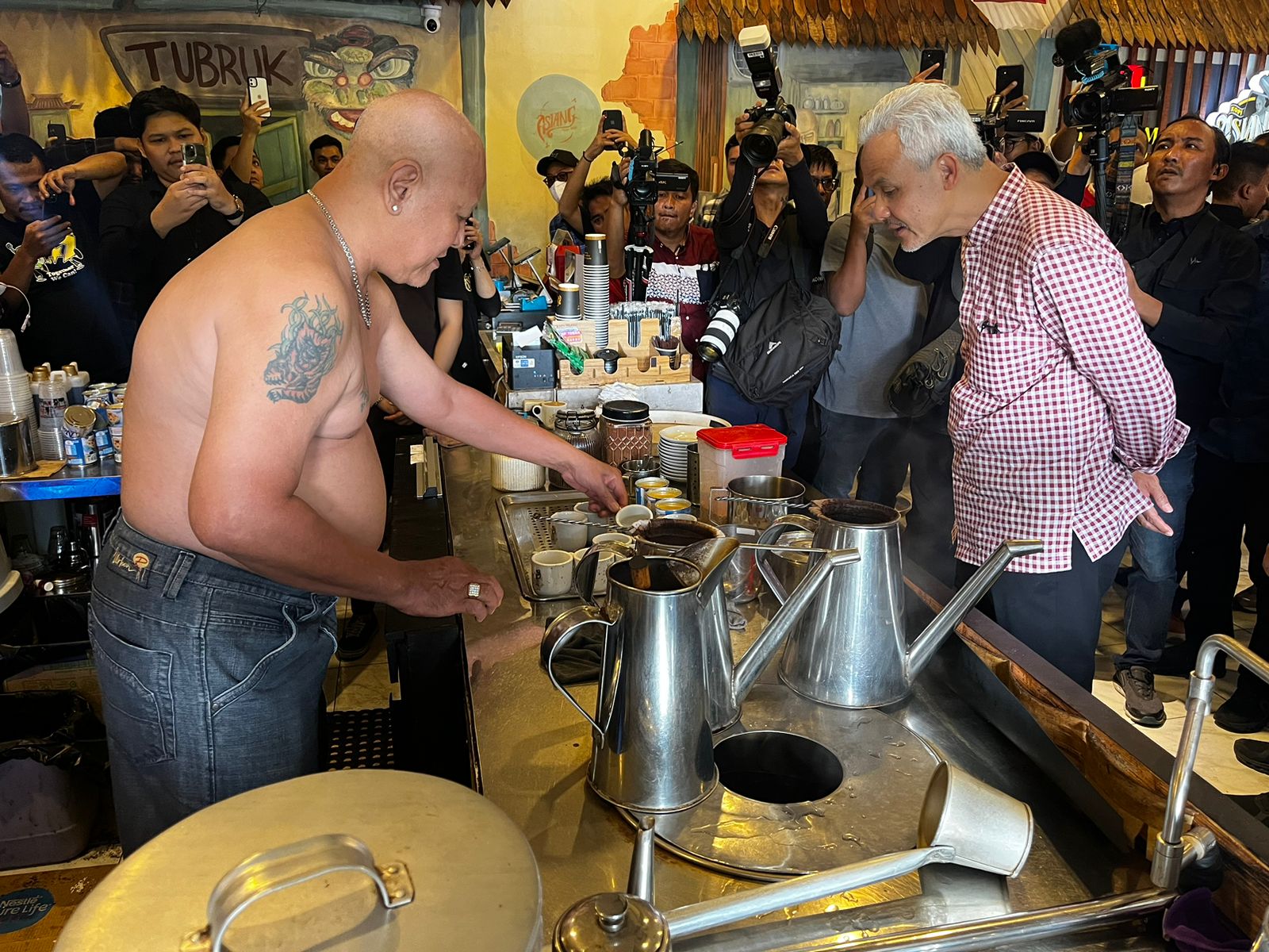 Ganjar Pranowo melihat proses penyeduhan kopi di Kafe Asiang, Minggu (26/11/2023). (Foto: Jauhari)