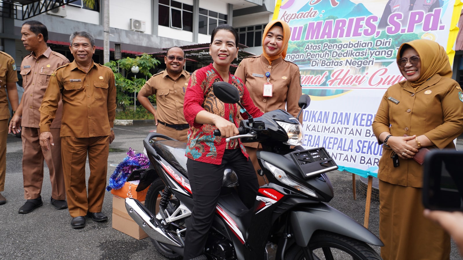 Kepala Dinas Pendidikan dan Kebudayaan Provinsi Kalimantan Barat, Rita Hastarita menyerahkan bantuan sepeda motor kepada Meries, seorang guru yang berada di perbatasan Kalbar atas pengabdiannya. (Foto: Jauhari)