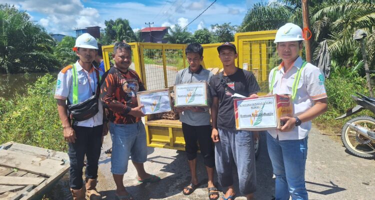 Perwakilan PT BGA Group menyerahkan bantuan sembako kepada masyarakat melalui Kepala Desa Ulak Medang, Kecamatan Muara Pawan, Rabu (29/11/2023). (Foto: Adi LC)