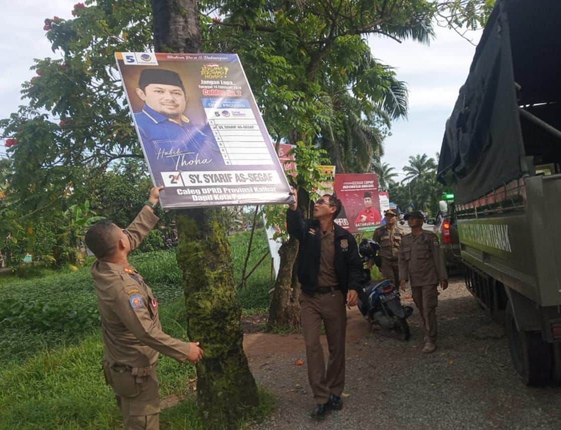 Petugas Satpol PP Kota Pontianak melakukan penertiban terhadap sejumlah baliho yang dipasang di pohon. (Foto: Prokopim Pontianak)