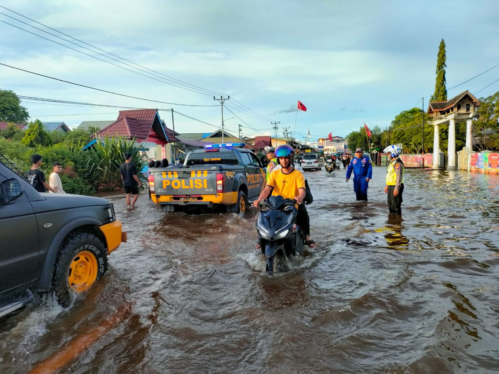 Petugas Satlantas Polres Kapuas Hulu mengatur lalu lintas di ruas jalan yang terdampak banjir di Kota Putussibau. (Foto: Ishaq)