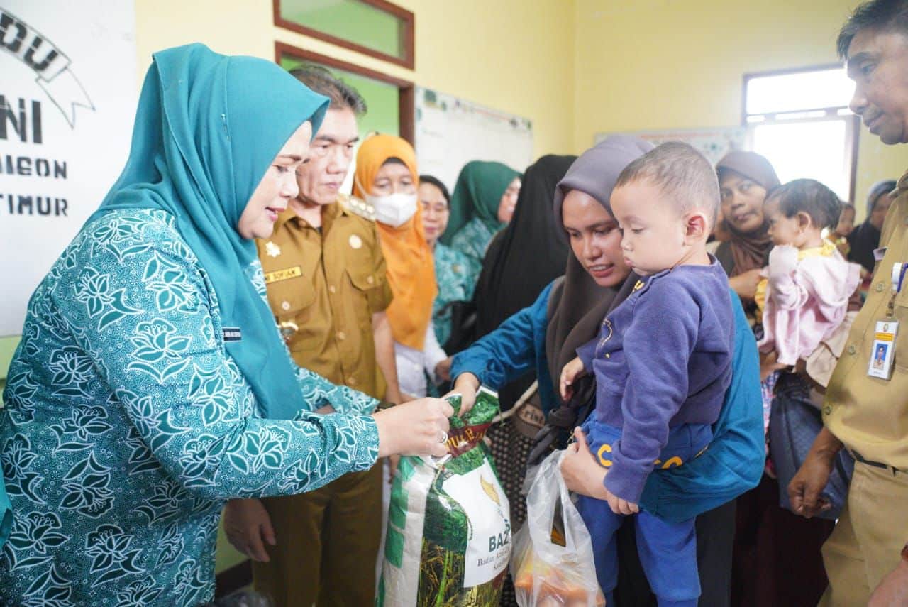 Pj Wali Kota Pontianak, Ani Sofian dan Pj Ketua TP PKK Kota Pontianak, Anita Ani Sofian menyerahkan bantuan pangan kepada warga untuk menangani stunting. (Foto: Kominfo/Prokopim Pontianak)
