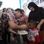 Pj Wali Kota Pontianak, Ani Sofian menyerahkan bantuan pangan bagi warga untuk menangani stunting. (Foto: Prokopim/Kominfo Pontianak)