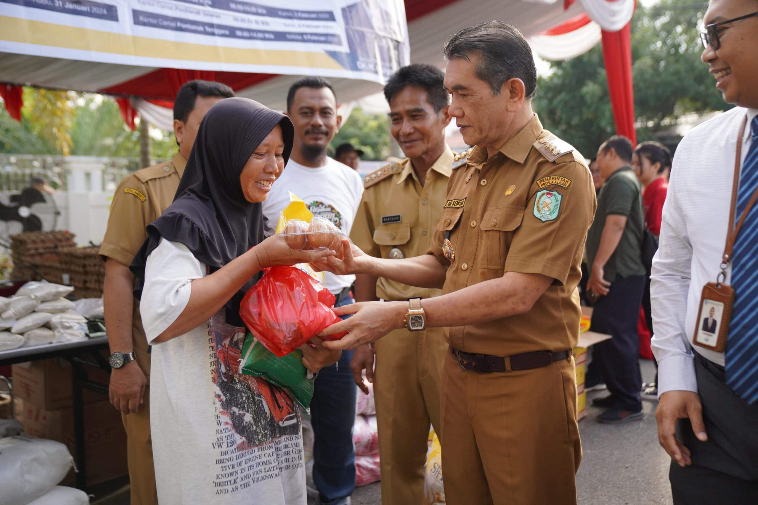 Pj Wali Kota Pontianak, Ani Sofian menyerahkan secara simbolis bahan pokok yang dibeli oleh warga pada Operasi Pasar di Kecamatan Pontianak Selatan. (Foto: Prokopim Pontianak)