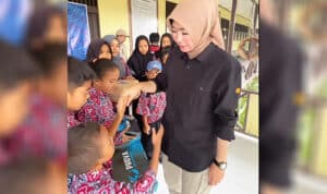 Kepala Dinas Pendidikan dan Kebudayaan Provinsi Kalbar, Rita Hastarita menyerahkan bantuan sepatu untuk siswa di batas negeri. (Foto: Dikbud Kalbar For KalbarOnline.com)
