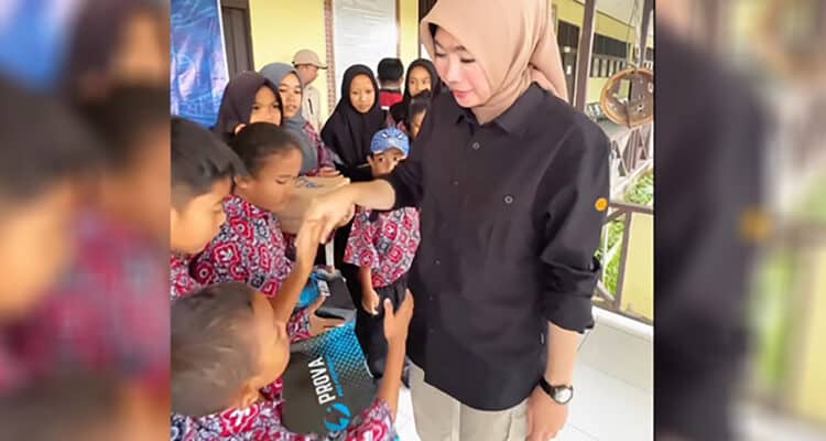 Kepala Dinas Pendidikan dan Kebudayaan Provinsi Kalbar, Rita Hastarita menyerahkan bantuan sepatu untuk siswa di batas negeri. (Foto: Dikbud Kalbar For KalbarOnline.com)