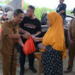 Pj Sekda KKU, Rene saat membagikan sembako di Pasar Rakyat, Kecamatan Sukadana, Selasa (06/02/2024). (Foto: Prokopim)