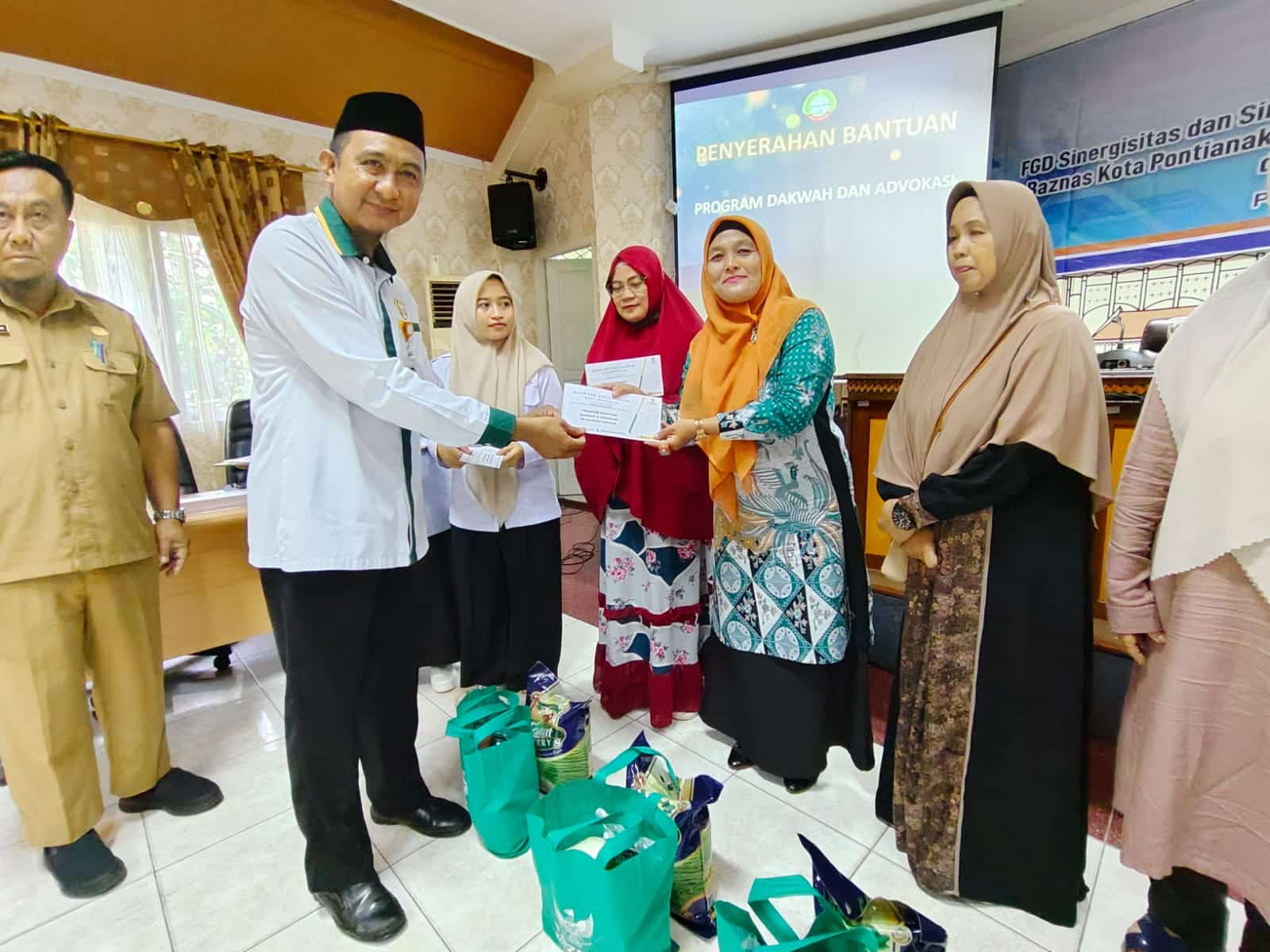 Ketua Baznas Kota Pontianak, Sulaiman menyerahkan bantuan paket sembako kepada orang tua balita. (Foto: Prokopim Pontianak)