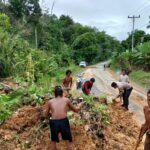 Personel Polsek Bunut Hulu dan Warga Gotong Royong Bersihkan Sisa Longsor di Ruas Jalan Nasional Dusun Muncin 15